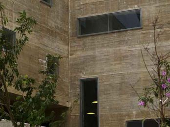 Fachada em concreto integralmente colorido: a textura similar à tela de madeira confere ao edifício a sua marcante presença. 