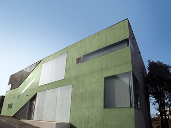 Uma das várias casas particulares em forma cúbica na Heyri Art Village, com fachadas em concreto verde (óxido de cromo verde).